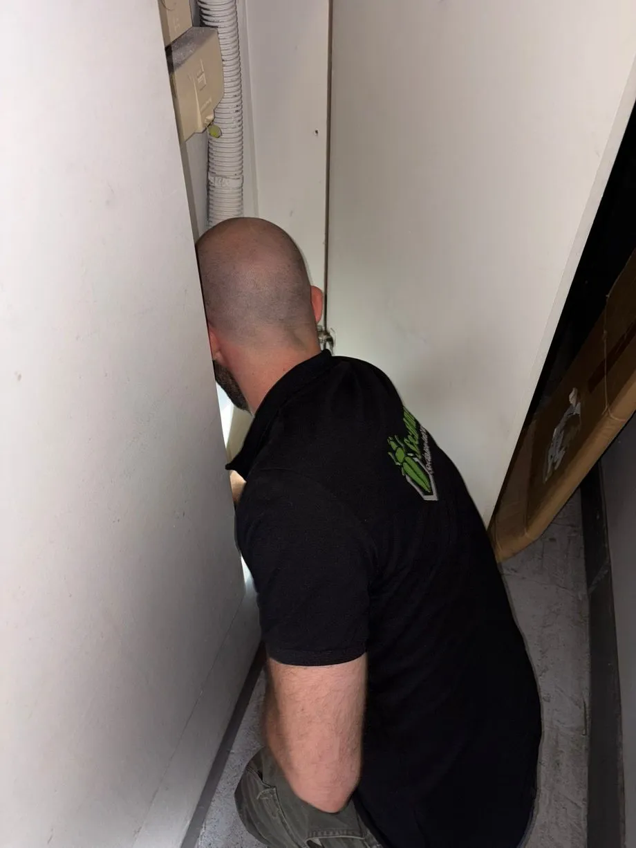 Technicien SafeHome3D ouvrant et inspectant les zones techniques (compteurs, plomberie) d'une copropriété à Paris 2e