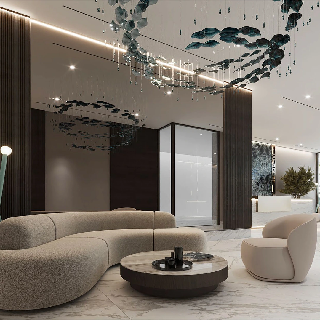 Modern lounge area with curved beige sofa, round marble coffee table, single armchair, and hanging abstract ceiling sculptures.