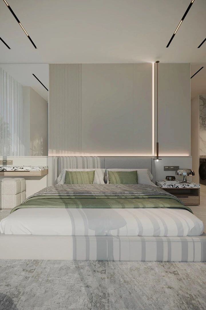 Modern minimalistic bedroom with a large bed featuring green pillows, a green blanket, and ambient wall lighting.