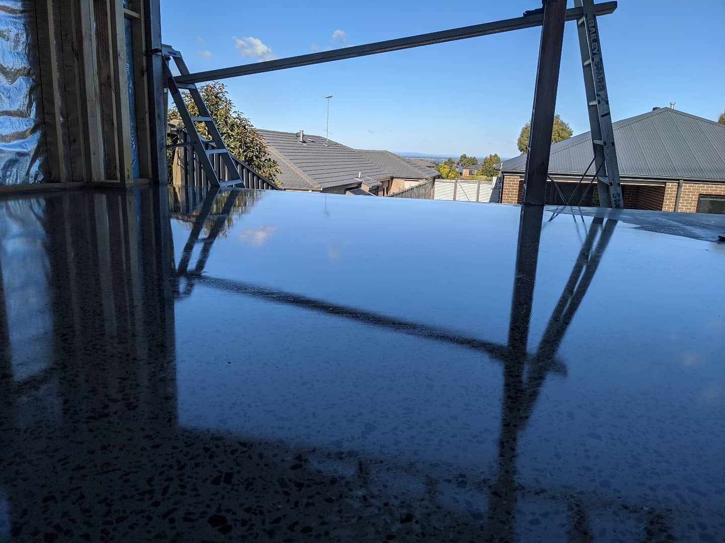 Polished concrete patio floor reflecting the sky and surrounding rooftops