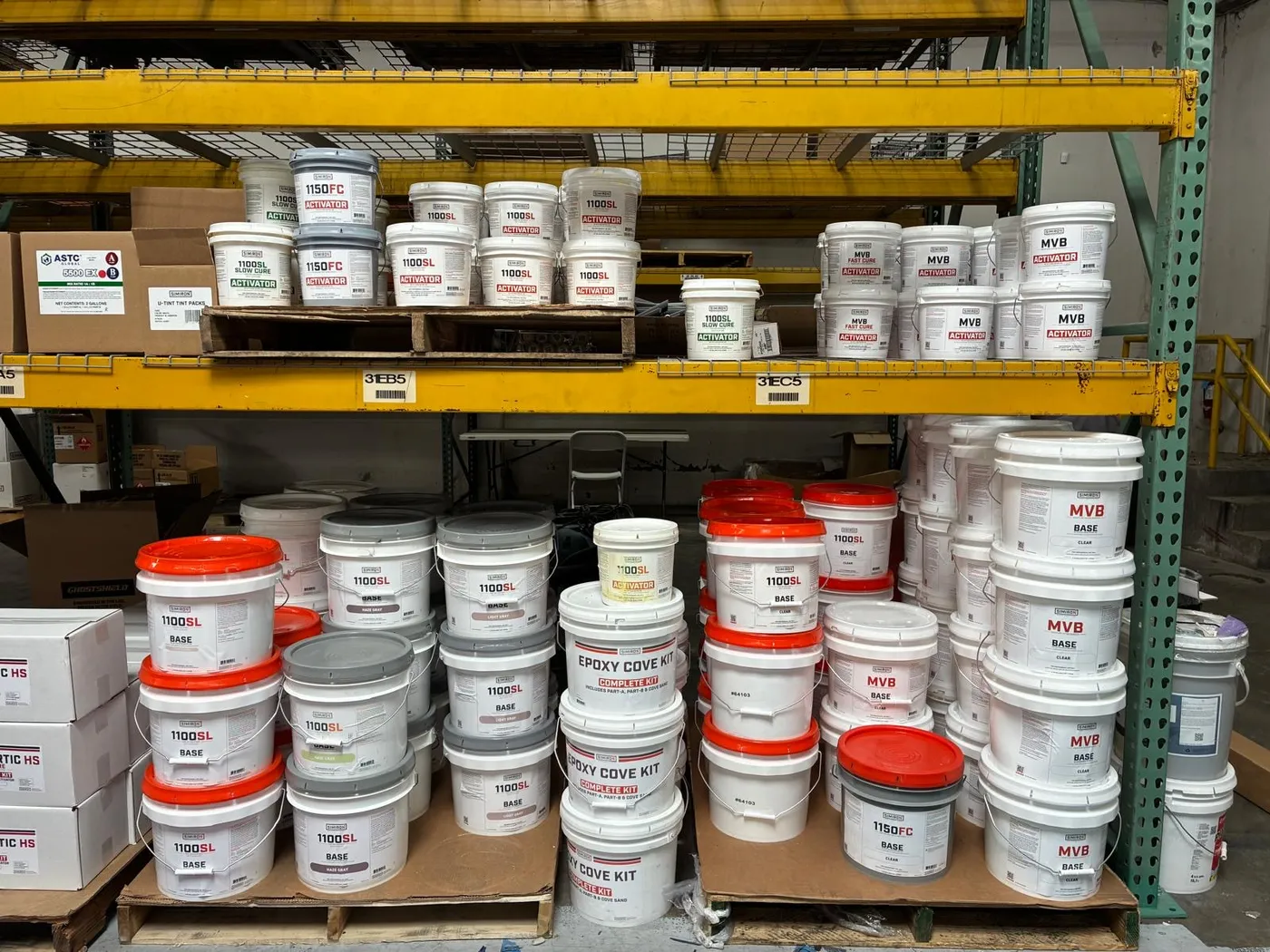 Warehouse shelves stacked with epoxy coating buckets and repair kits