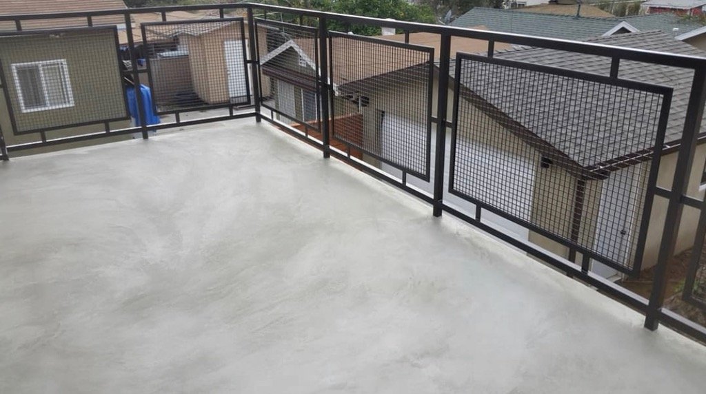 Micro-Cement finish applied to a rooftop deck with metal railing