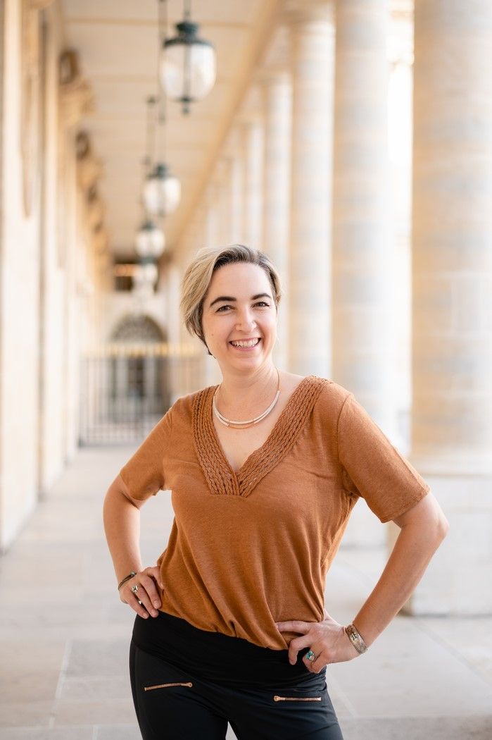 Lindsey, standing in a colonnade
