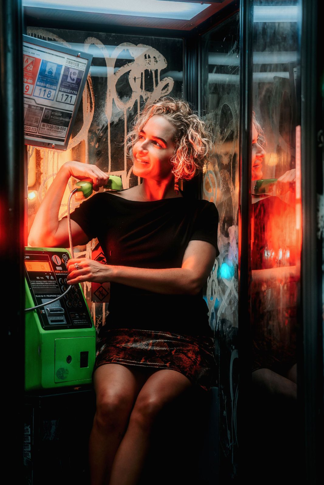 A woman on the phone at night, lit red
