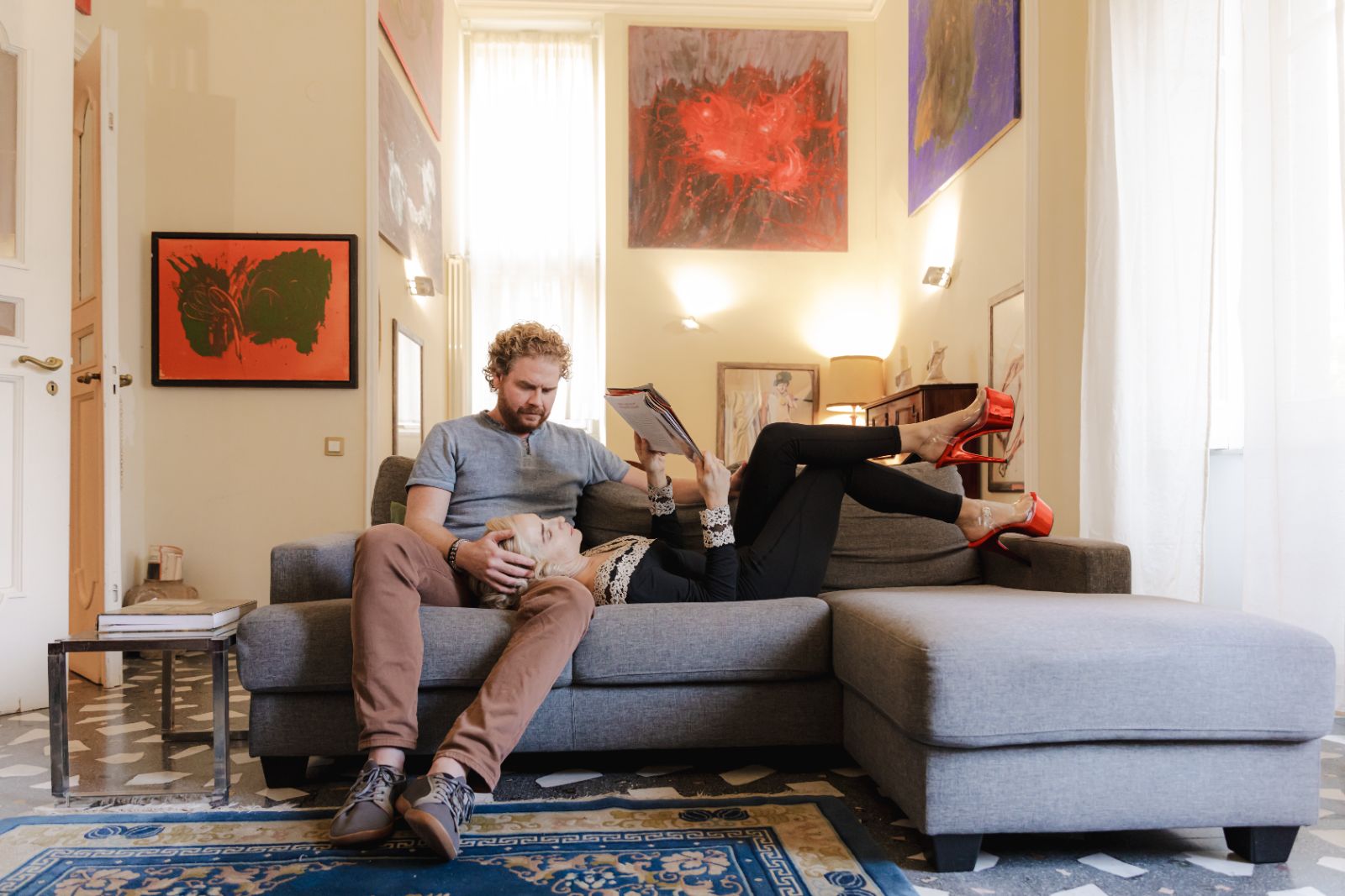 A couple on a sofa in an art-filled apartment, unhurried