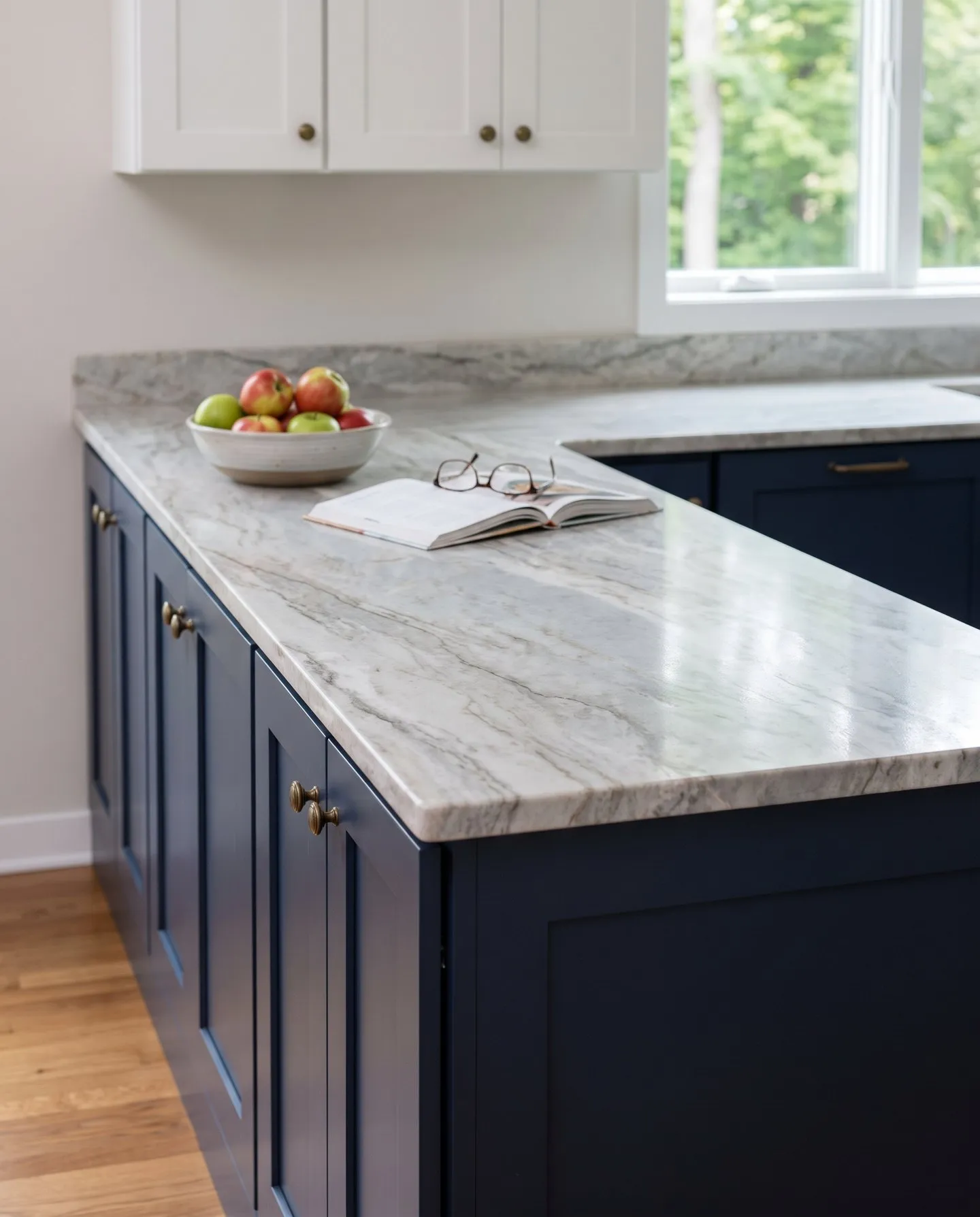 Gray and white natural stone countertop on navy shaker cabinets