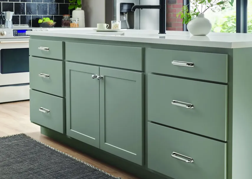 Top Knobs polished pulls and knobs on a sage green kitchen island