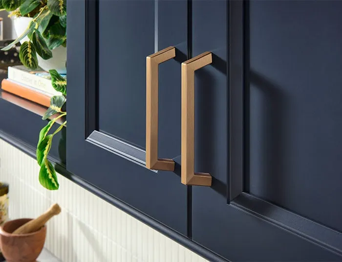 Jeffrey Alexander squared brass pulls on navy cabinet doors