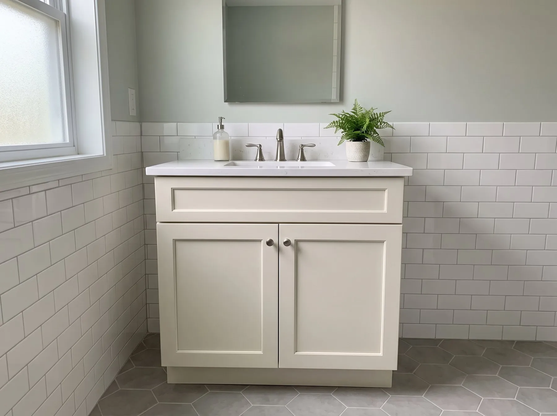 Off-white single-basin shaker vanity with nickel knobs and a white top in a tiled hall bath
