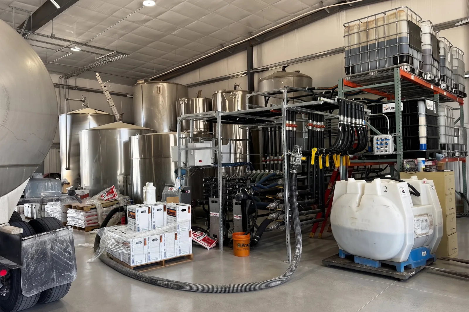 Plant overview: tote rack feeds the stacks, bulk tanks behind