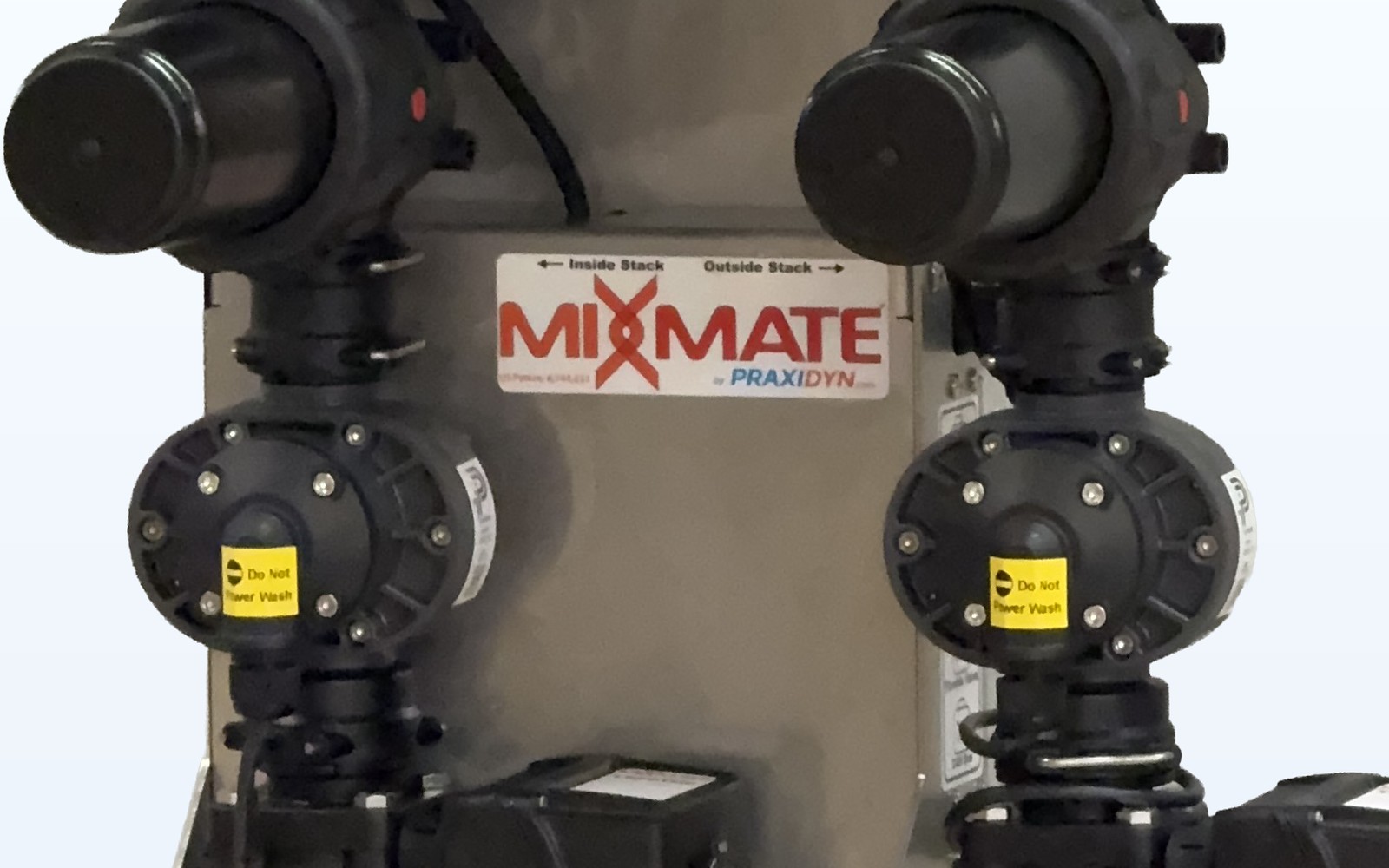 Close-up of two factory-calibrated gear meters on a Mixmate double valve stack