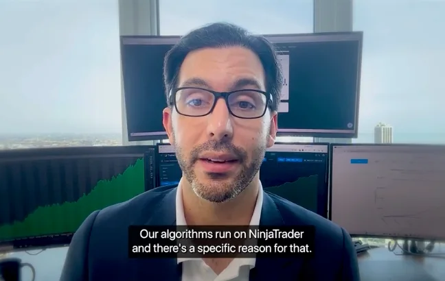 Video still of a Vincere trader at his desk in front of trading screens