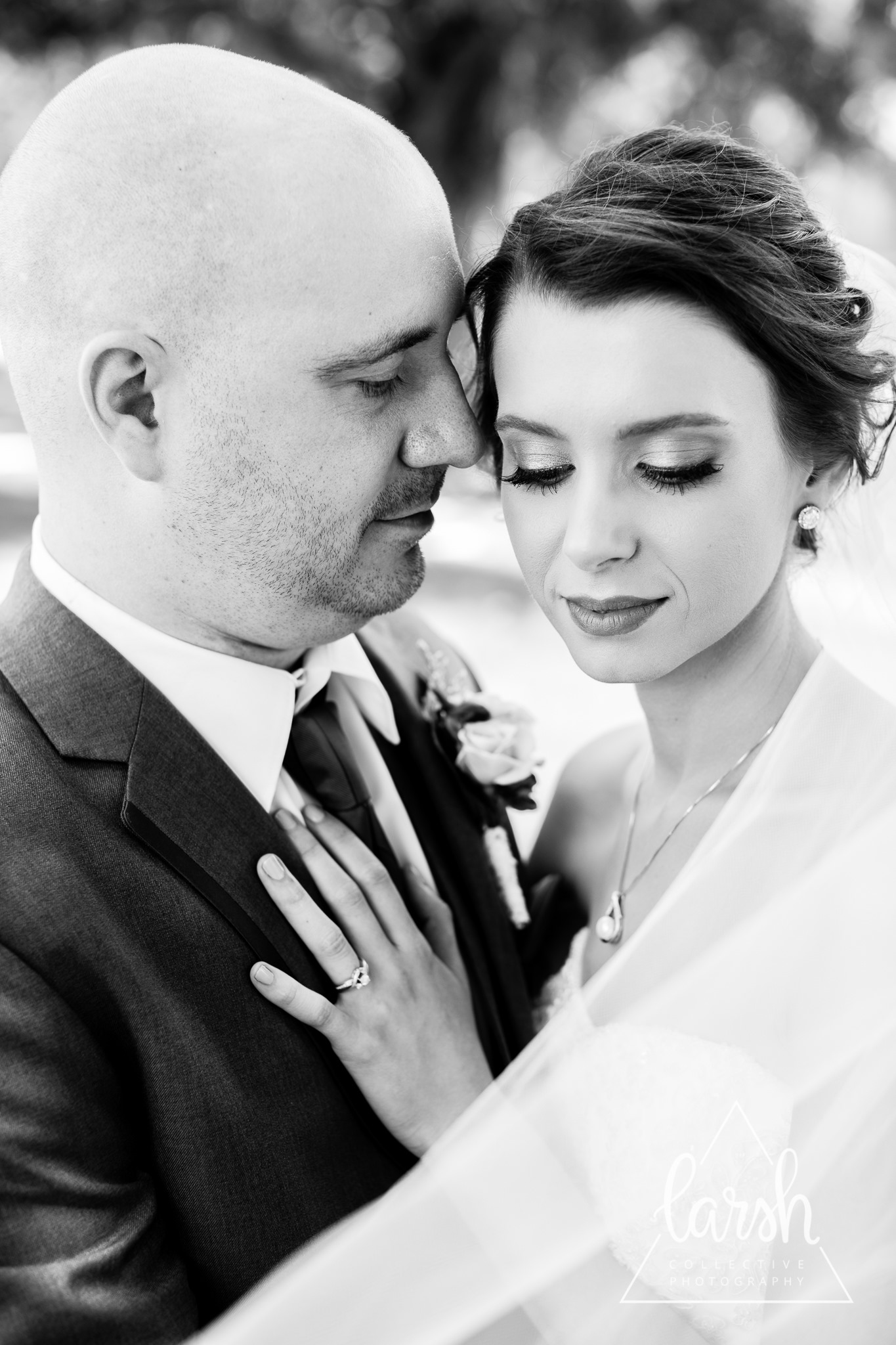 Black and white close-up of a bride and groom embracing on their wedding day.