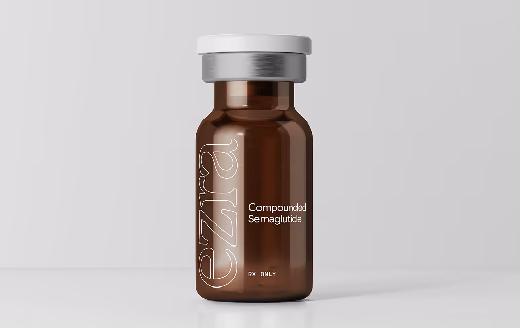 Clear vial with black cap labeled 'ezra Compounded Semaglutide RX ONLY' with a cloudy sky background on the label.