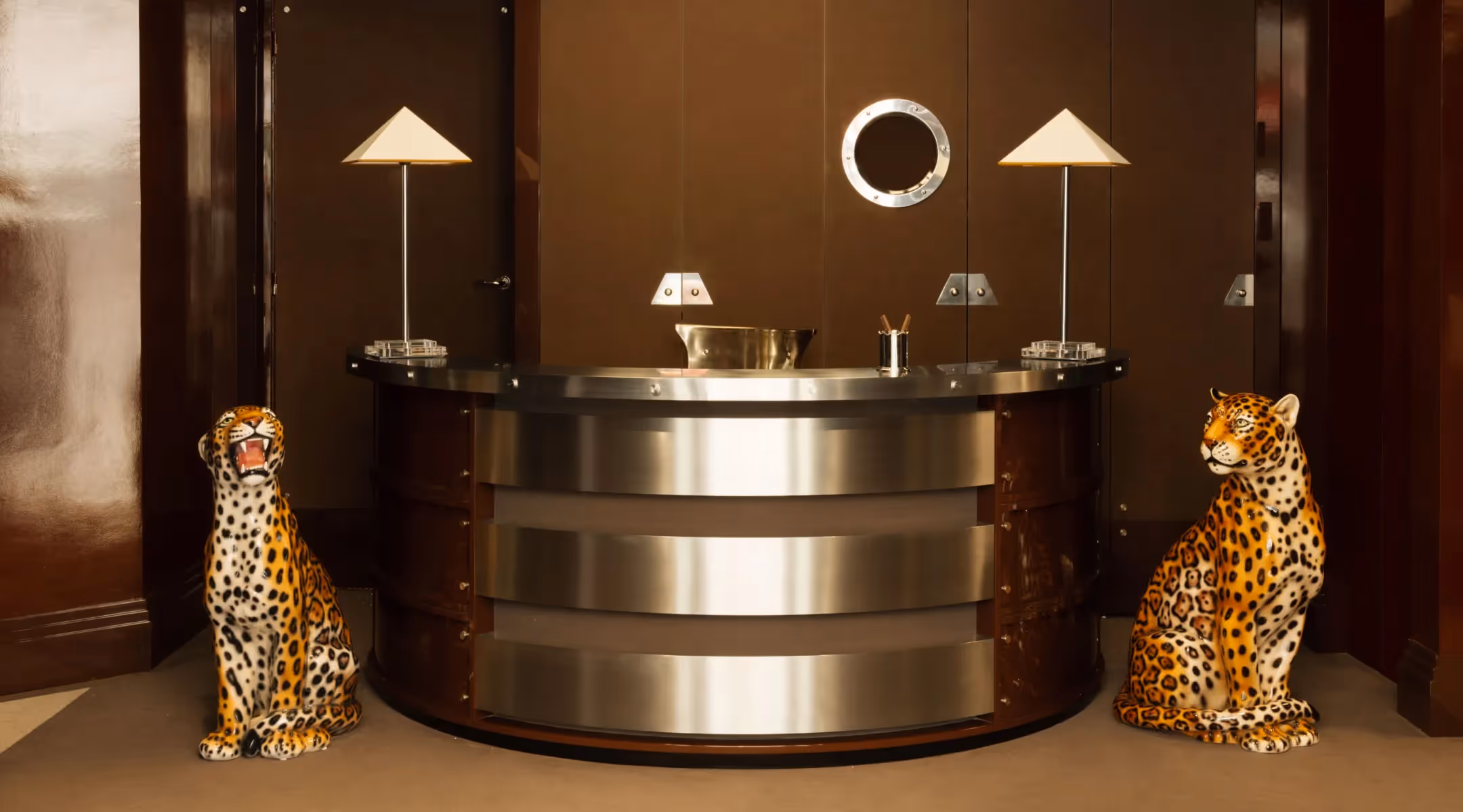 Designer reception desk surrounded by two ceramic leopard statues, 4-star Hôtel Château d’Eau, Paris.
