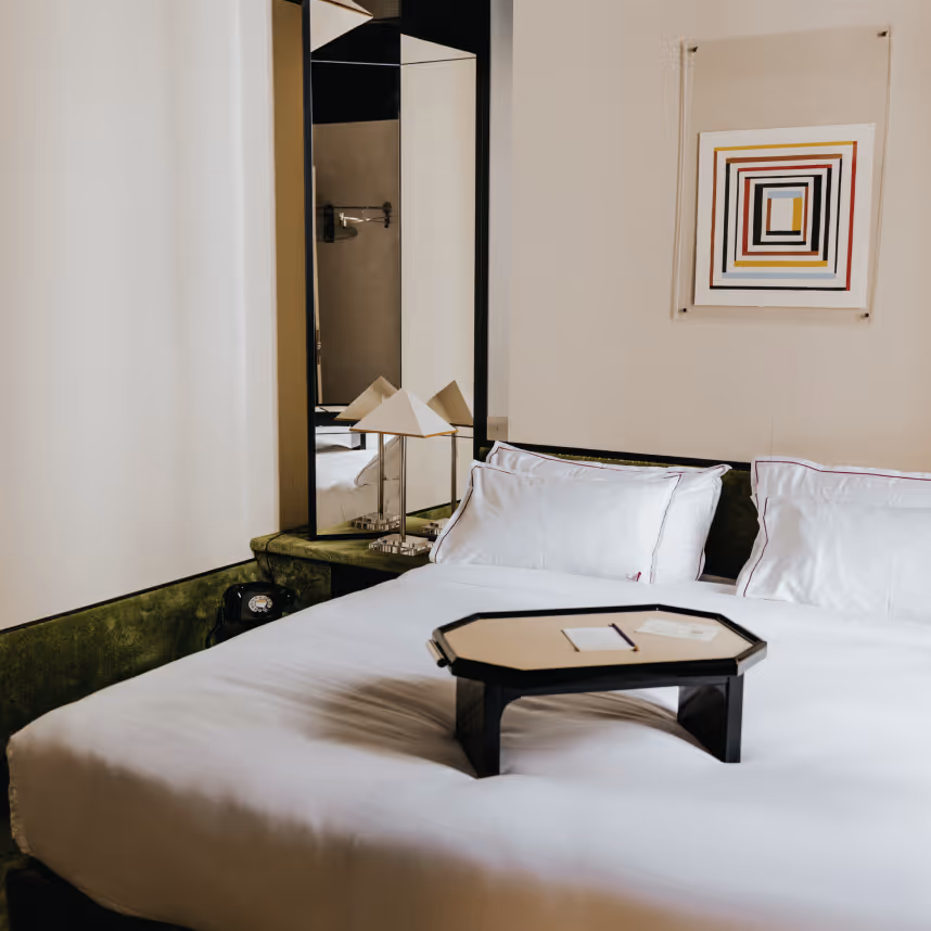 Room with rotary phone, bed tray and mirror, four-star Hotel Château d’Eau, Paris.