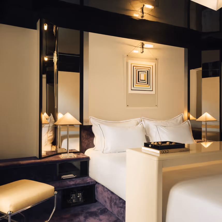 Seventies style room, bed, triangular lamp and mirror, four-star Hotel Château d’Eau, Paris 10th arrondissement.