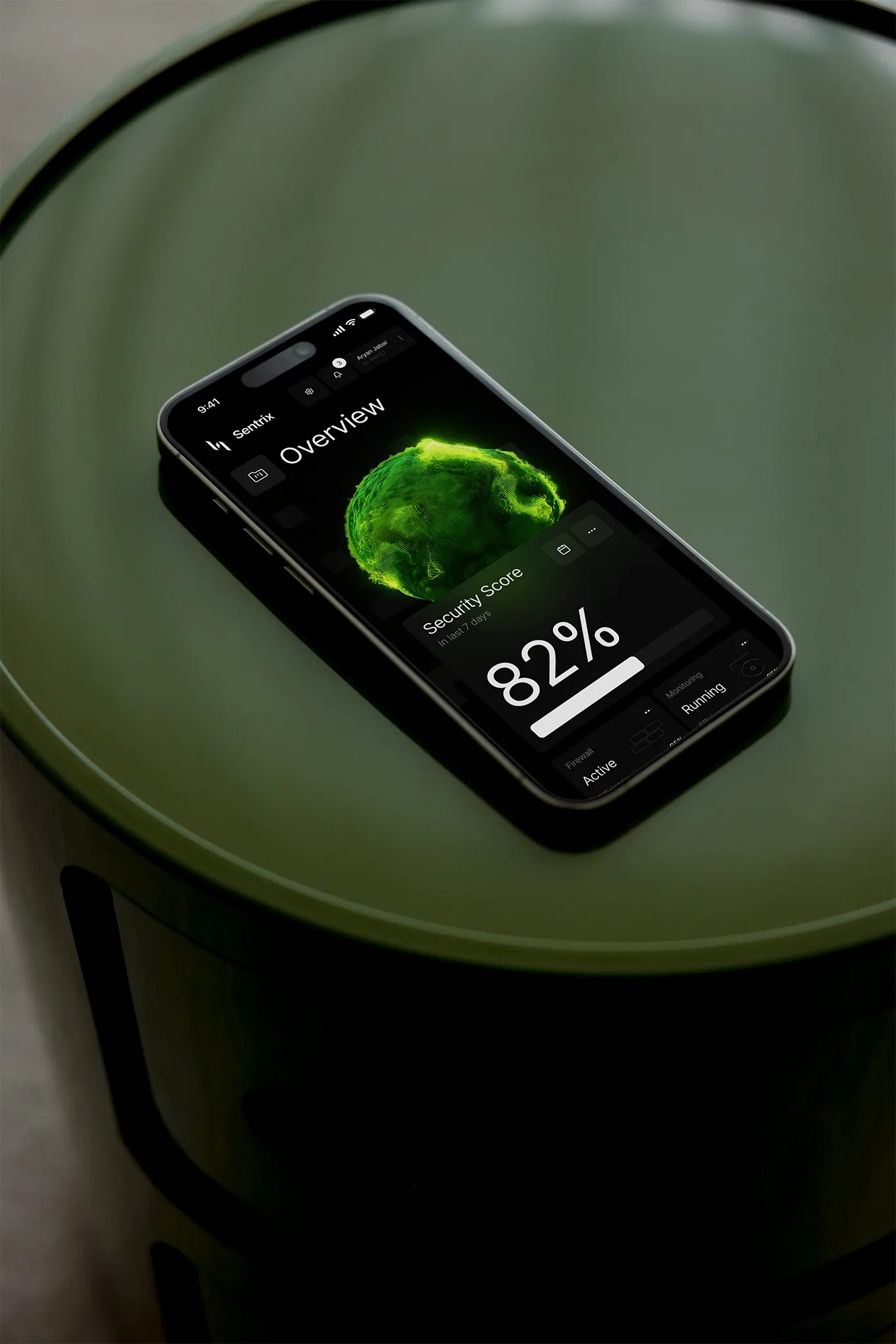 Black iPhone displaying a dark-themed security app with an 82% security score and a glowing green brain graphic, resting on a green circular table.