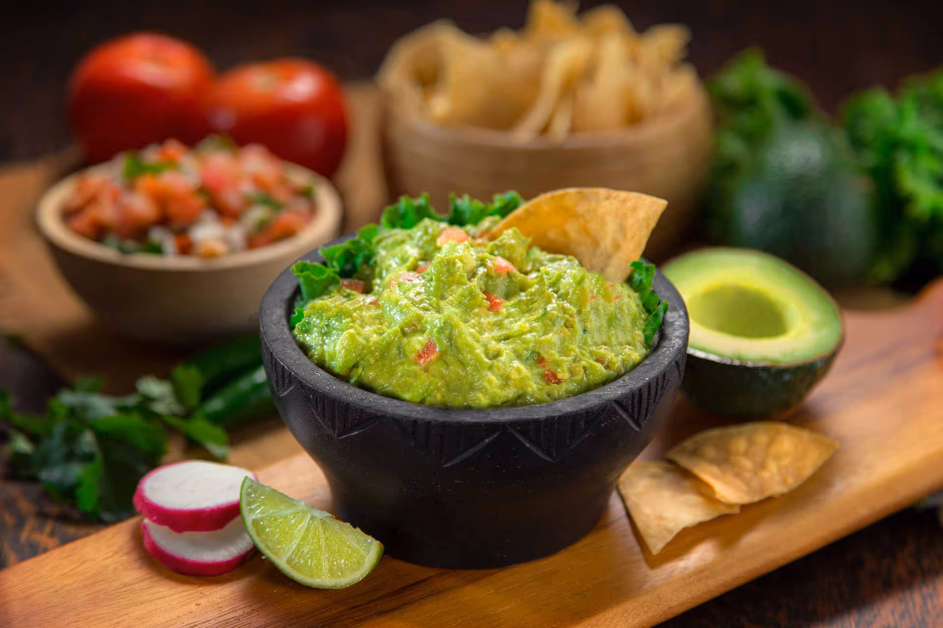 A bowl of guacamole with a tortilla chip on top.