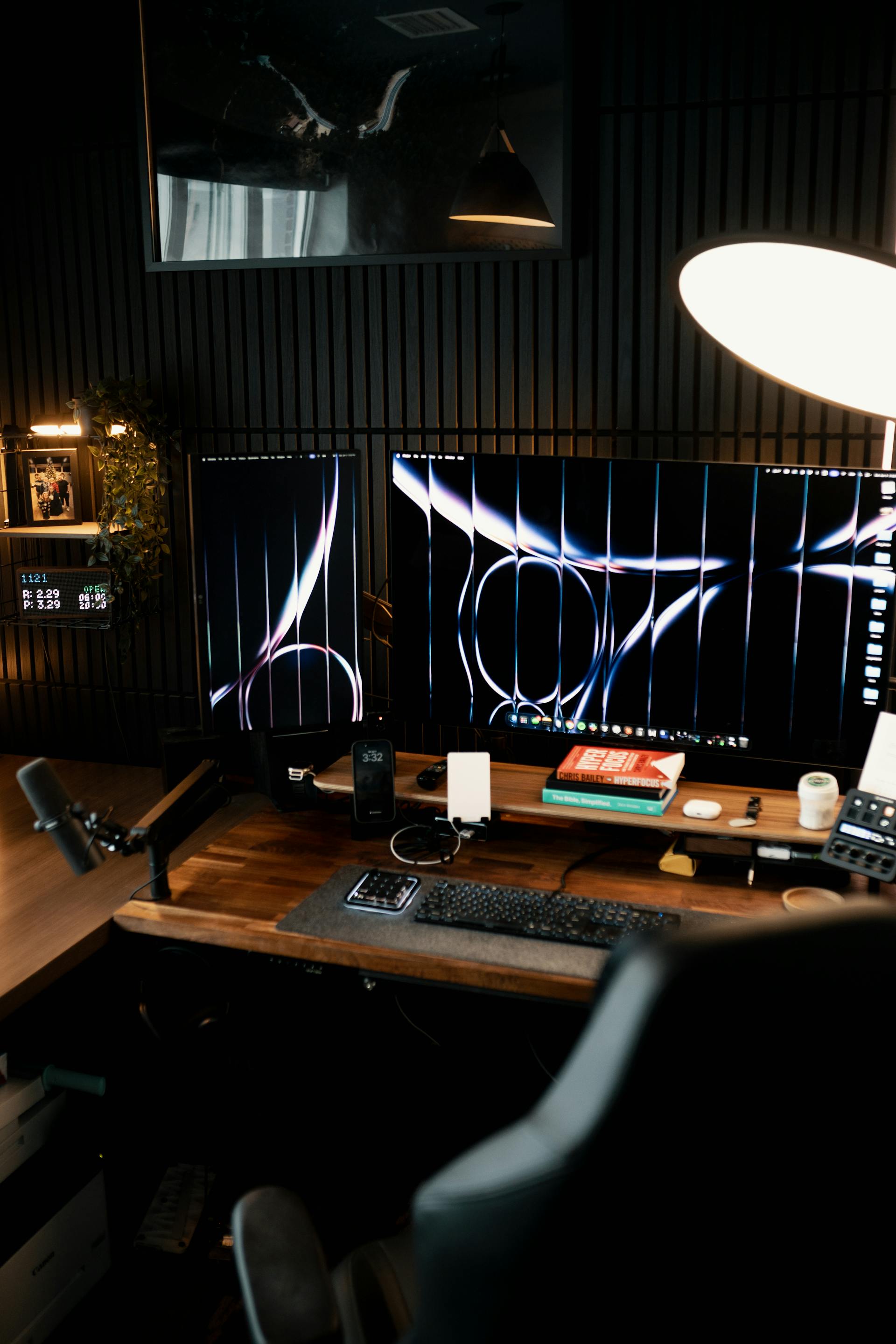 Poste de travail ergonomique et moderne avec deux grands moniteurs affichant des graphismes d'IA, un bureau en bois massif et une chaise gamer, symbolisant la productivité d'une agence web.