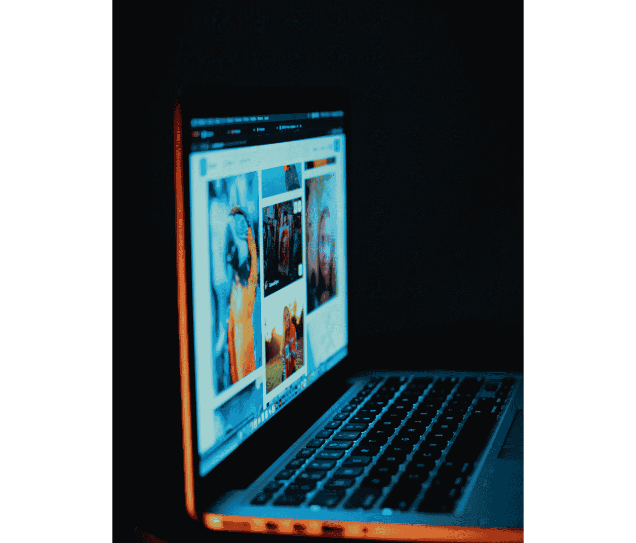 Vue d'un ordinateur portable ouvert dans un environnement sombre, affichant une mosaïque de contenus sociaux créatifs, symbolisant la gestion et l'animation de communauté.