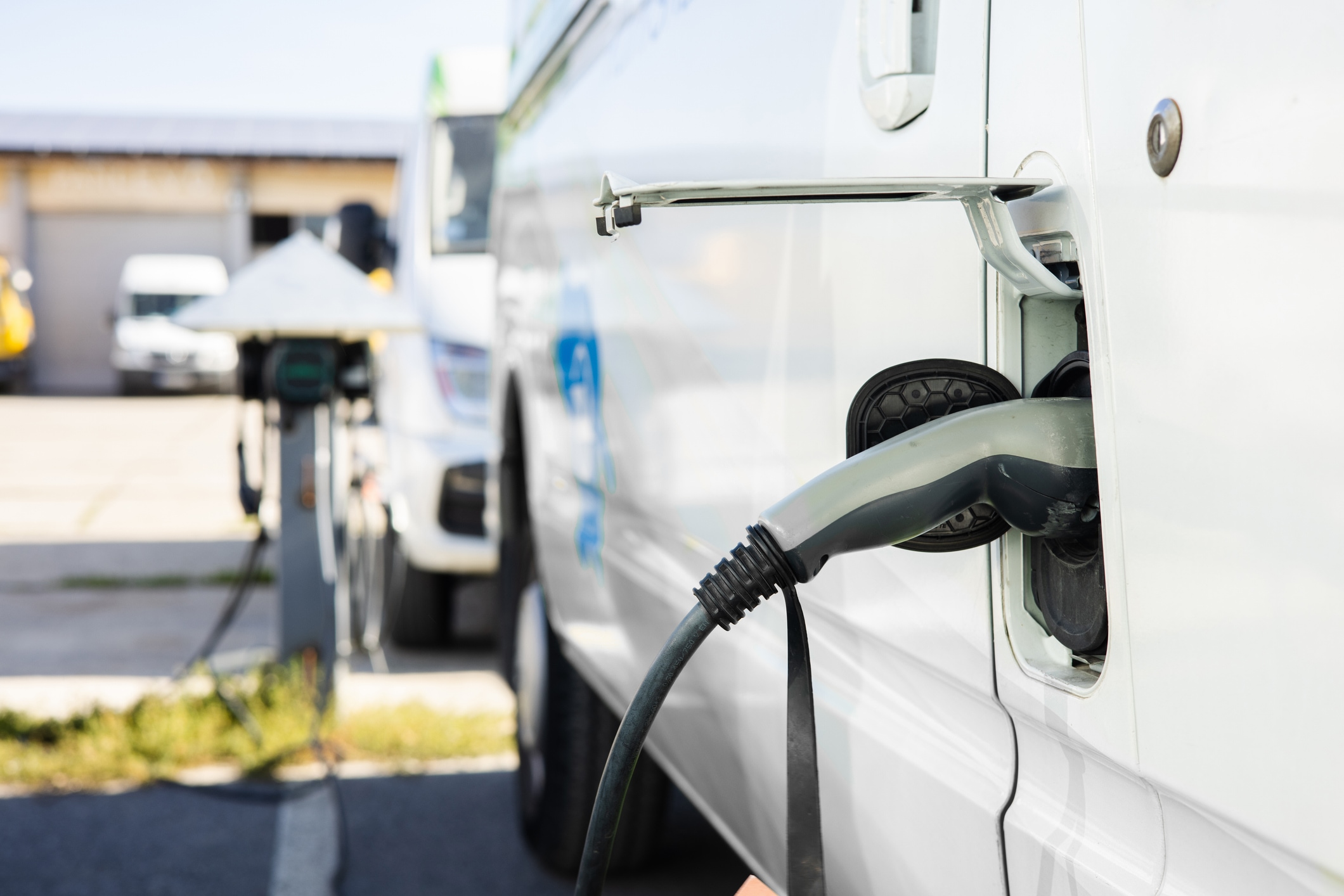 Close-up of an electric vehicle charging with a charging cable plugged into the car.