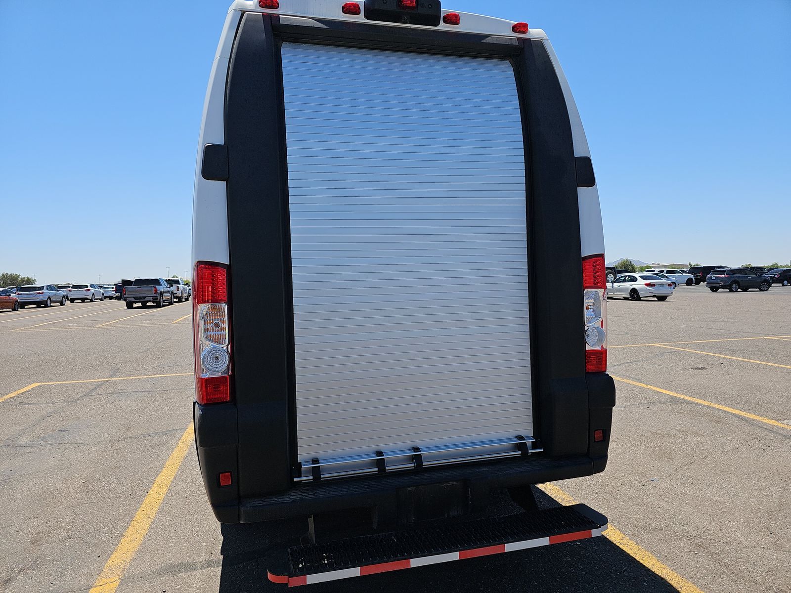 Rear of a white Ram ProMaster EV with roll-up cargo door