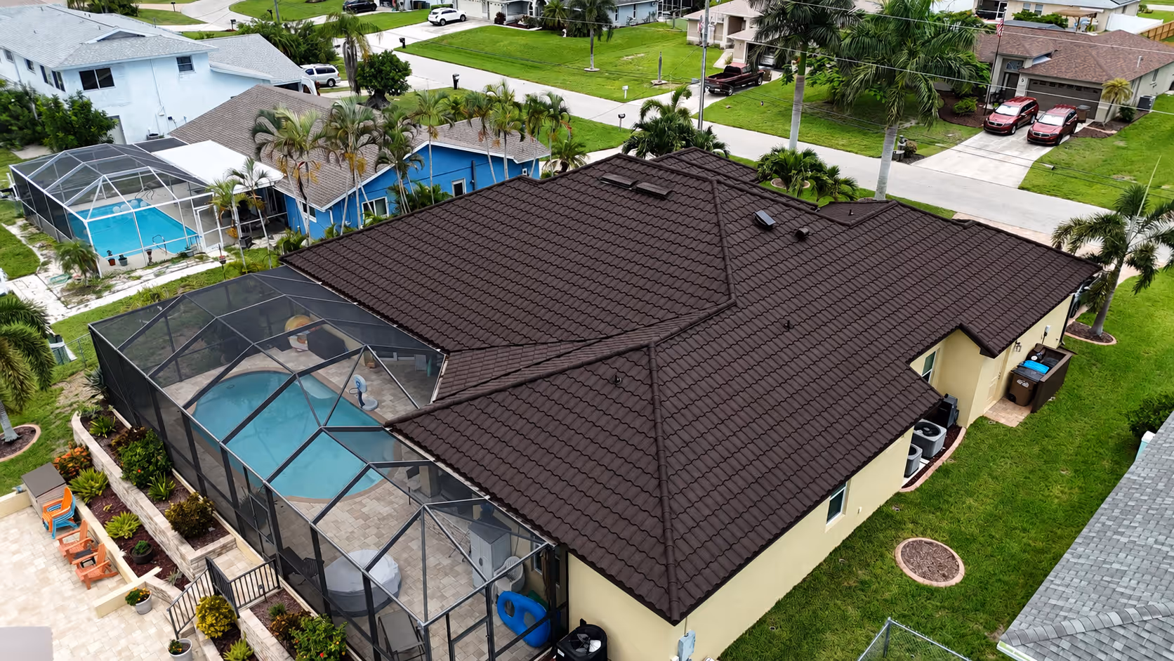 Aerial view of a house with a dark brown tiled roof and enclosed swimming pool patio.