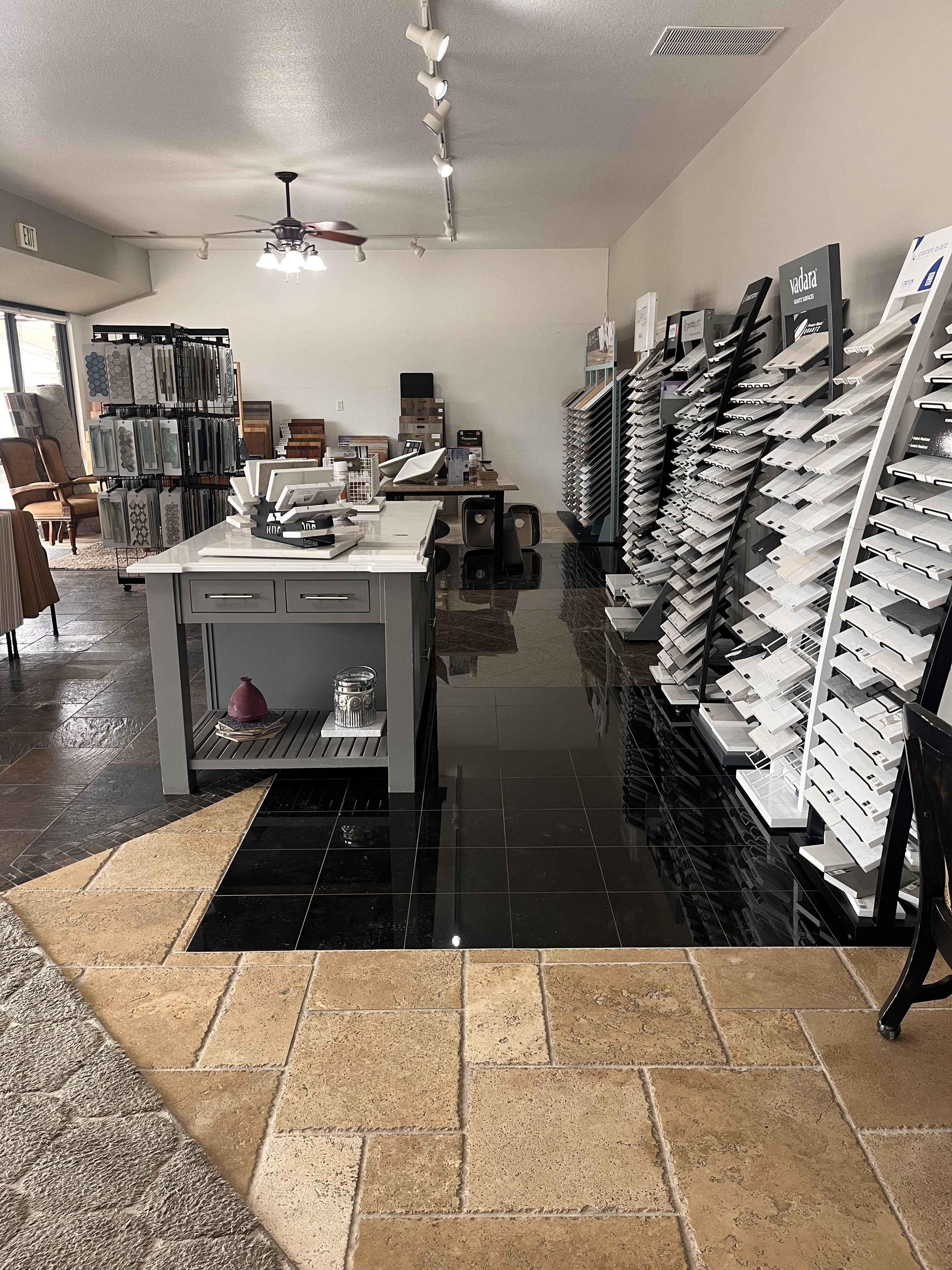 Interior of a showroom displaying various tile samples on racks and tables.