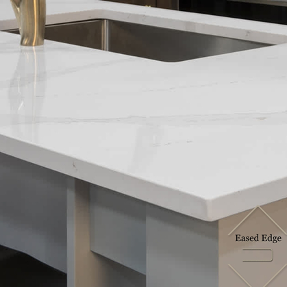 White marble kitchen countertop with eased edge finish and an undermount stainless steel sink.