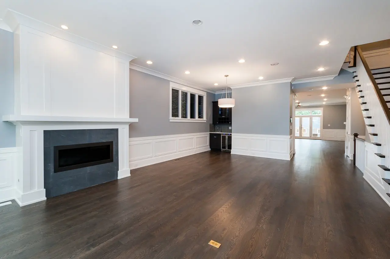 Open-concept living area with a linear fireplace and staircase visible in the background.