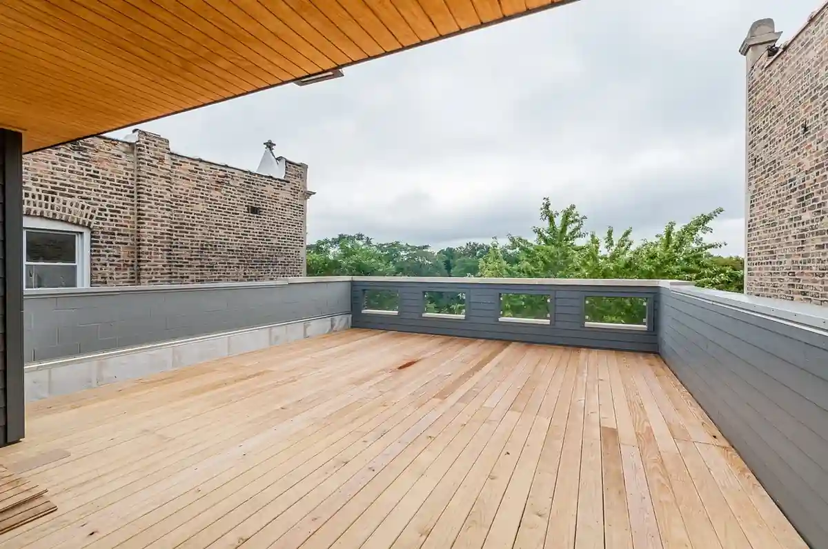 Rooftop deck of the Campbell New Construction home with wood decking and a treetop view.