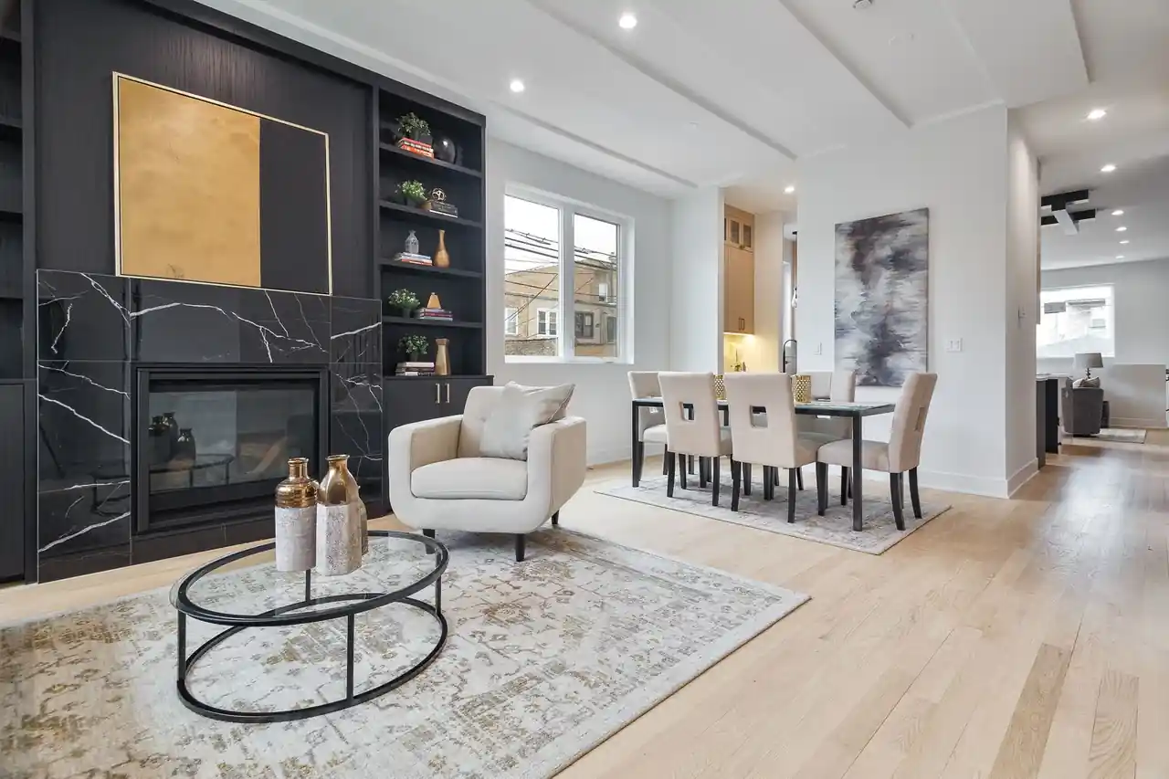 Living room with a black marble fireplace, gold-leaf art panel, and open sightline to the dining table.