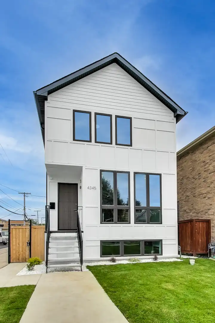 Two-story home with light gray siding and black-trimmed windows — the New Castle New Construction project exterior.