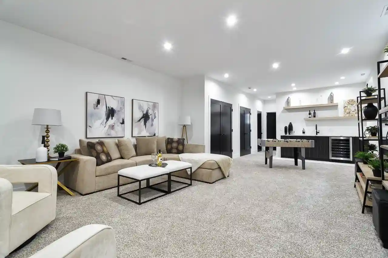 Finished basement rec room with a foosball table, built-in wet bar, wine fridge, and sectional seating.
