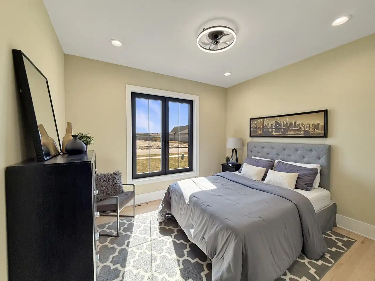 Bedroom featuring skyline artwork above a tufted headboard, with French doors to the yard.