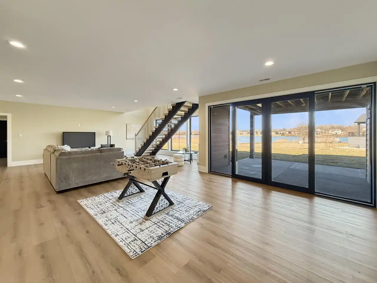 Walkout family room with floor-to-ceiling glass doors opening onto the lakefront yard.