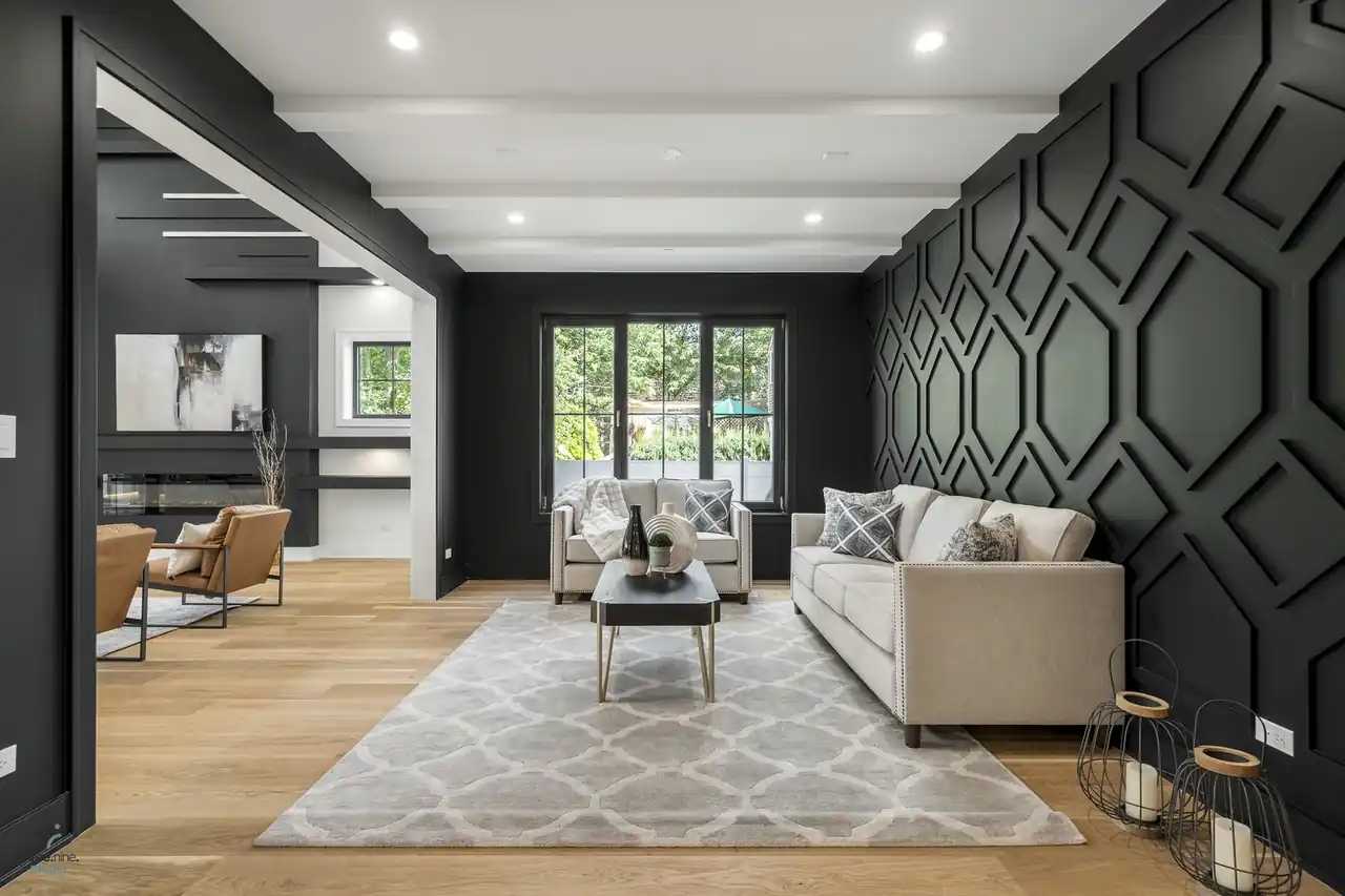 Living room featuring a geometric black accent wall and leather lounge chairs
