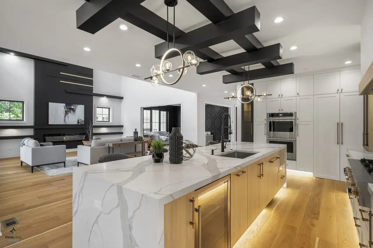 Open kitchen looking into the living room with a black accent wall and built-in shelving