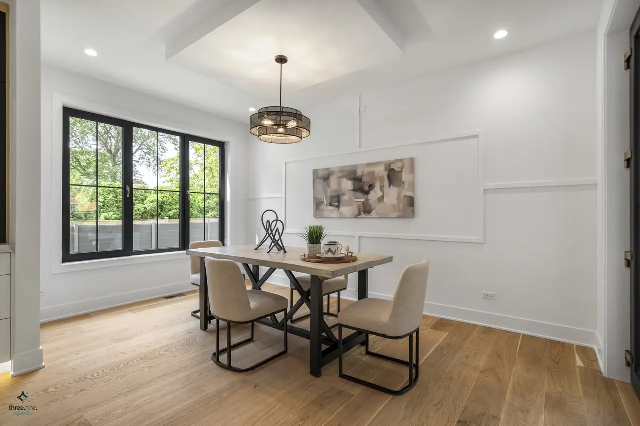 Breakfast nook with wainscoted walls and a drum-style chandelier over a wood table