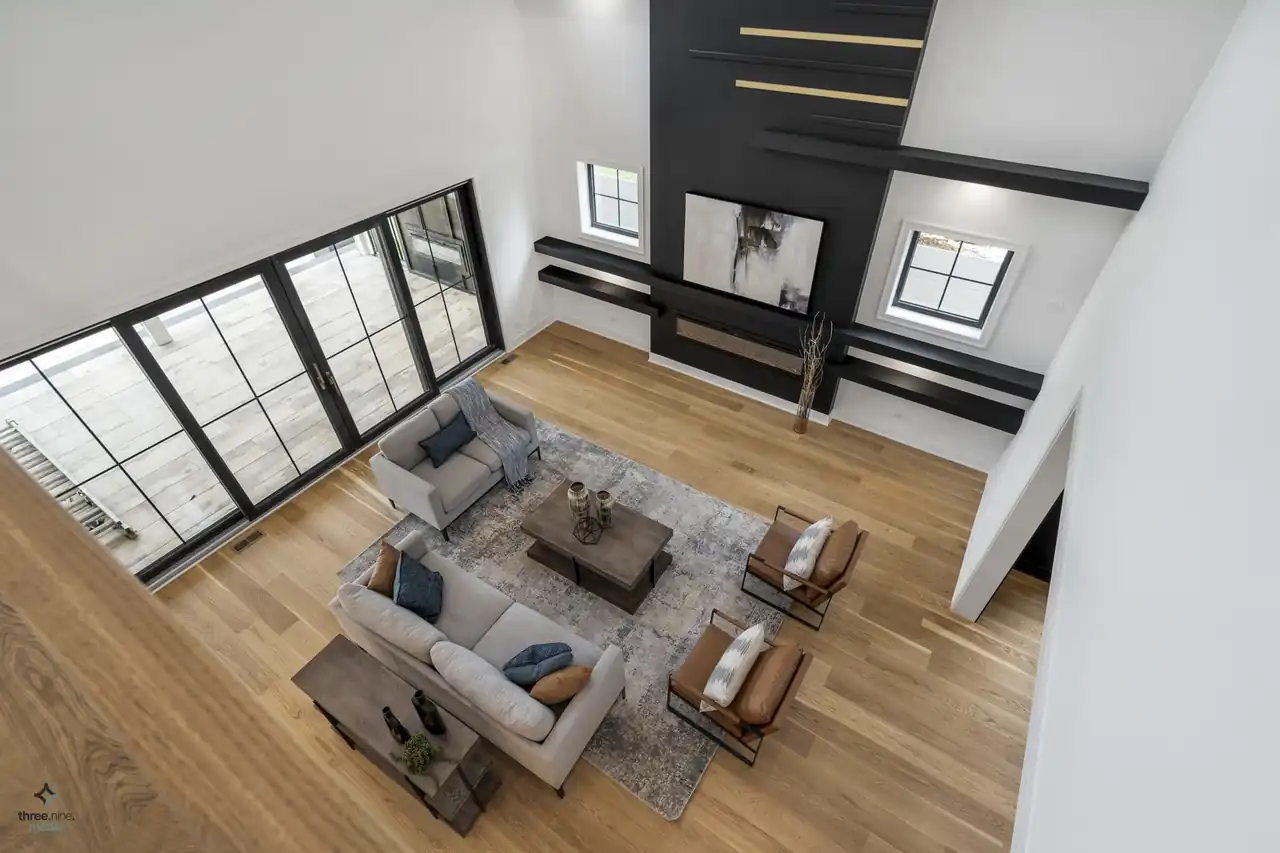 Aerial view into the vaulted living room and rear patio doors from the upstairs loft