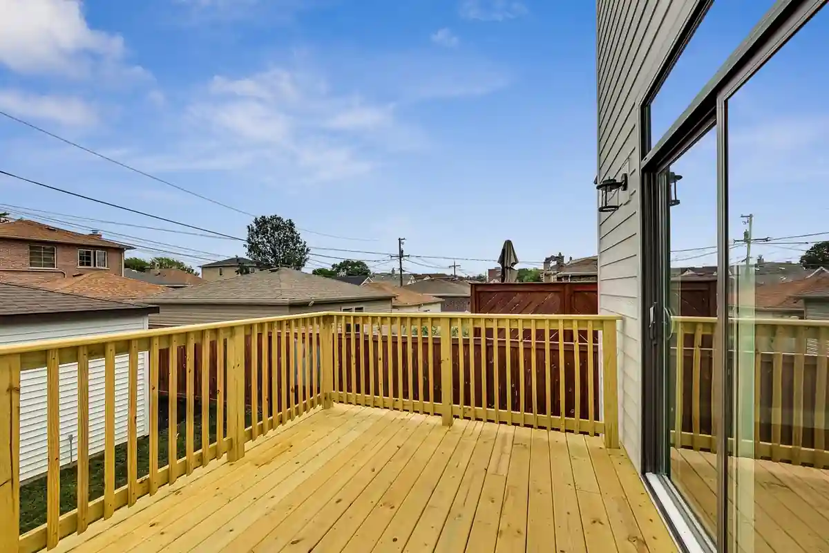 Deck view overlooking the wood railing and surrounding neighborhood rooftops.