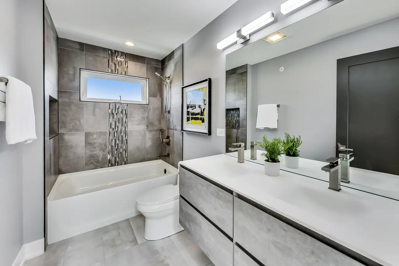 Full bathroom with a tub-shower combo, a mosaic tile accent strip, and a single vanity.