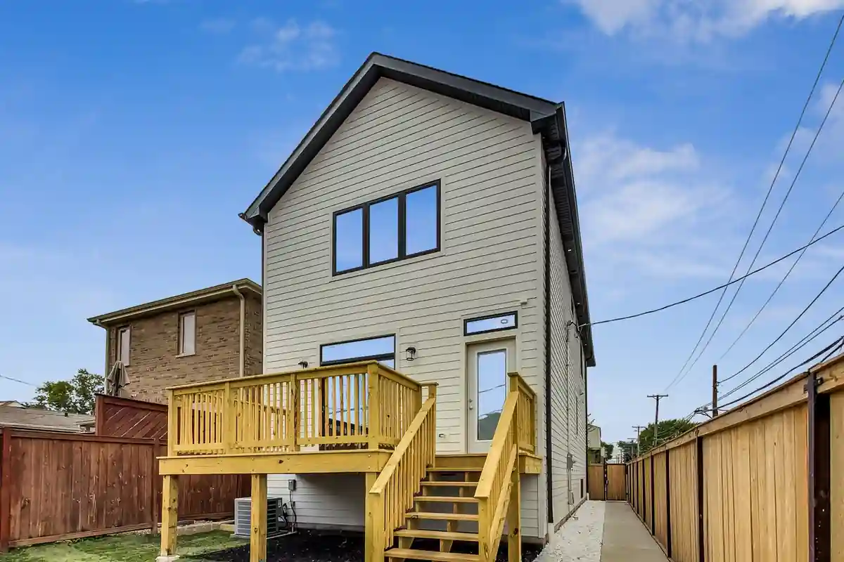 Rear view of the New Castle New Construction home showing the raised wood deck and stairway to the yard.