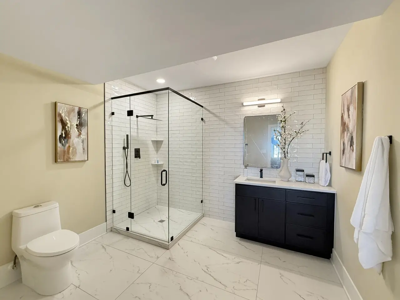 Bathroom with a glass-enclosed subway-tile shower and a dark navy vanity.