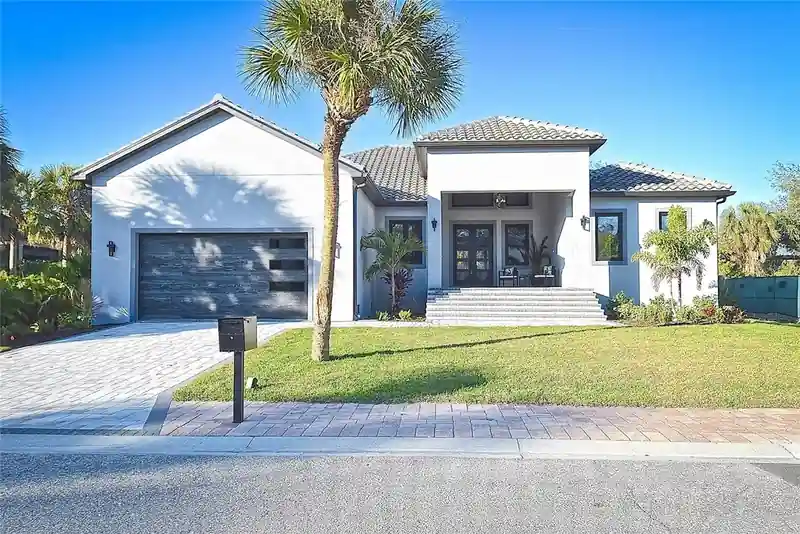 Topsail New Construction exterior with a tile roofline, paver driveway, and mature palm framing the entry.