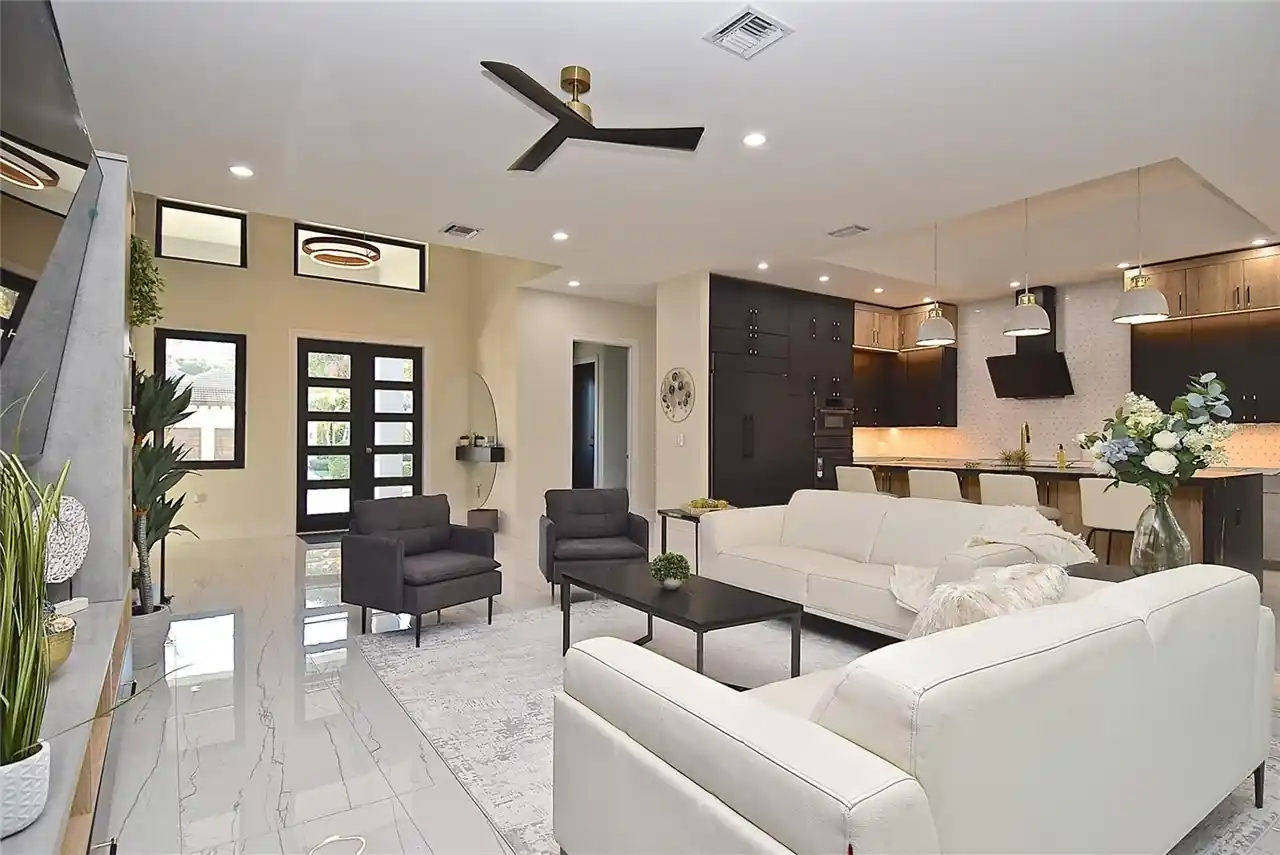 Open-concept living area with a white sectional flowing into the kitchen beyond.