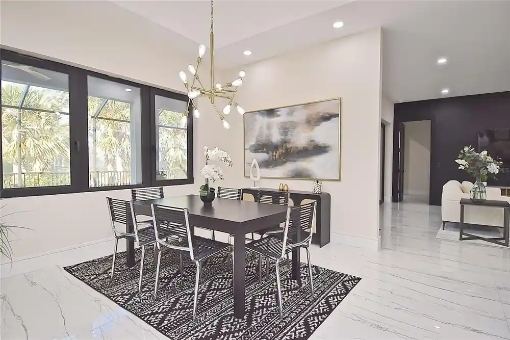Dining area with a dark wood table, wire-back chairs, and a brass sputnik chandelier.