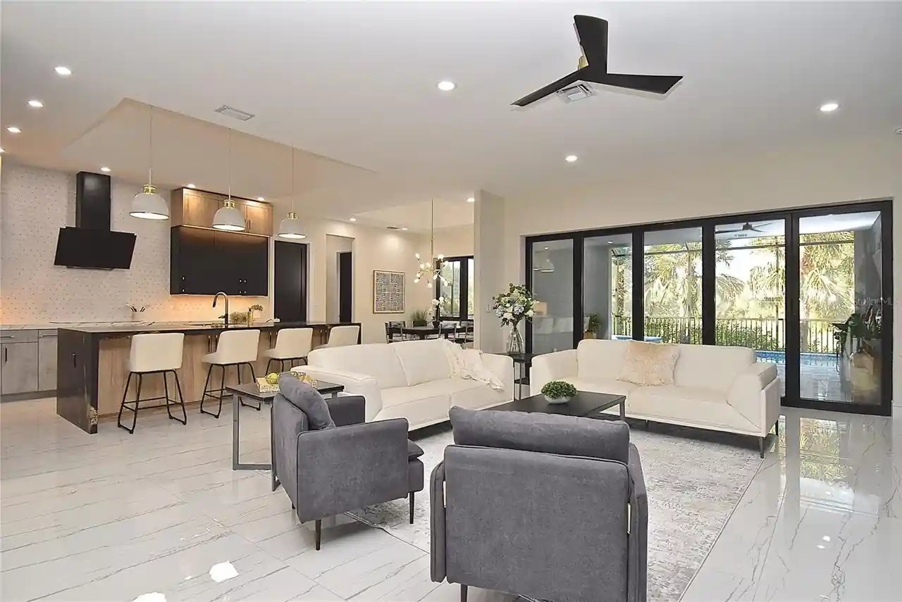 Great room with a kitchen island and folding glass doors opening to the pool lanai.