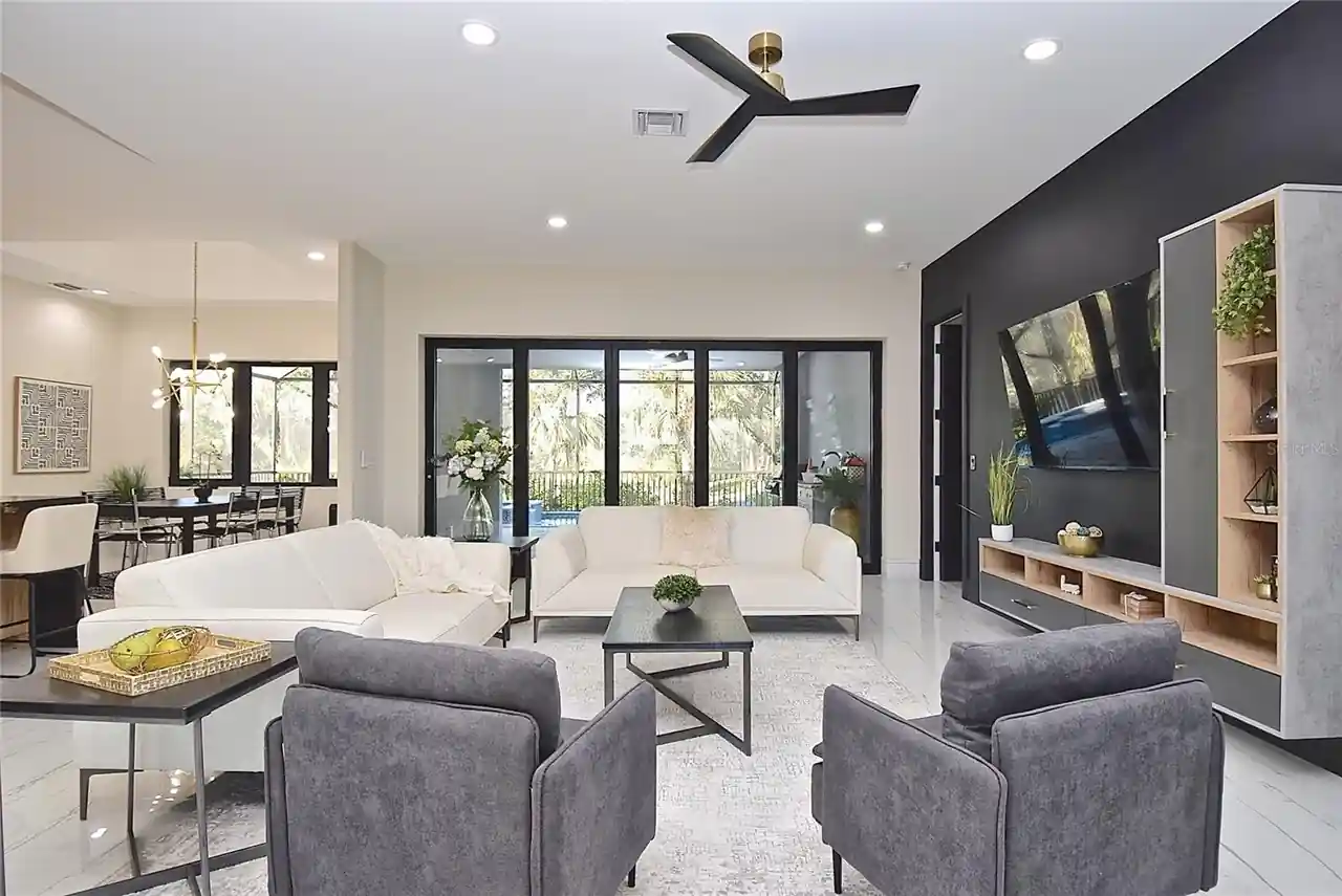 Family room with a dark accent wall and sliding glass doors leading out to the pool.